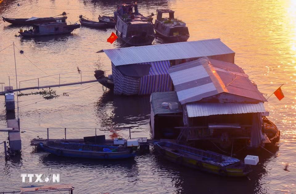 Giữa dòng sông lững lờ, vài chiếc ghe thuyền neo đậu, xuôi ngược mang đặc trưng vùng Nam Bộ. (Ảnh: Duy Khương/TTXVN)