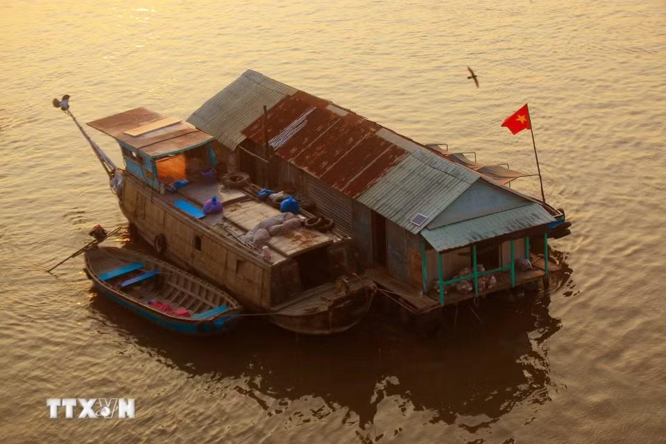 Giữa dòng sông lững lờ, vài chiếc ghe còn neo đậu mang đặc trưng của Nam Bộ. (Ảnh: Duy Khương/TTXVN)