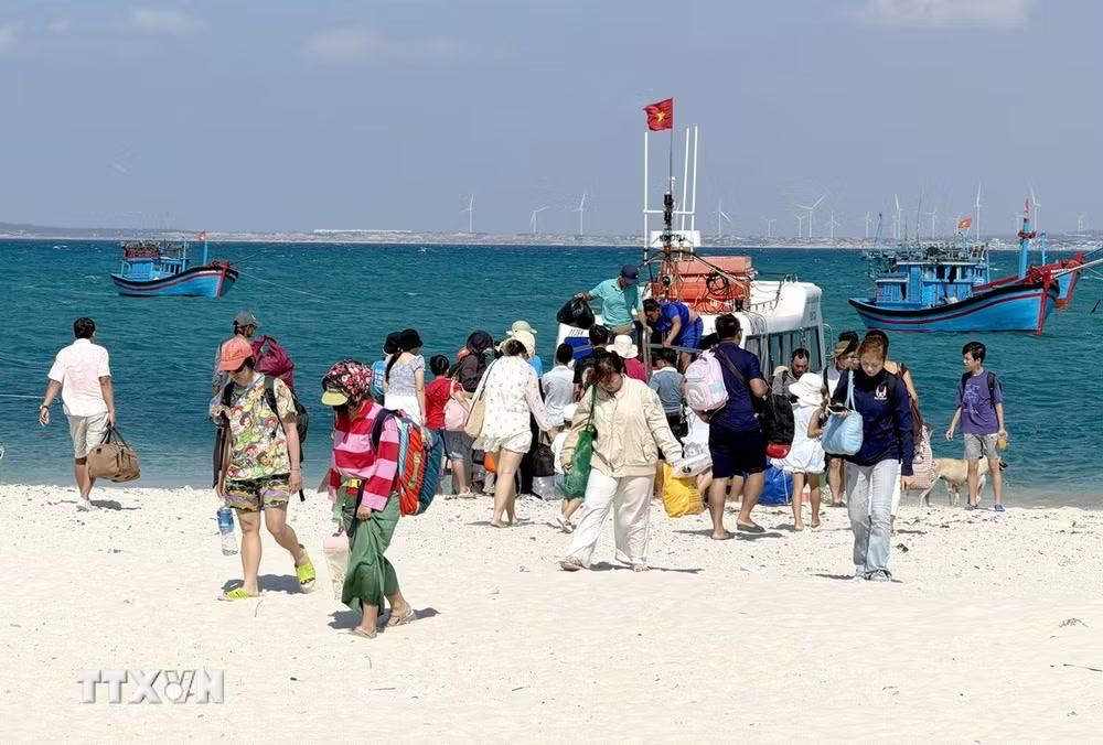 Du khách đi tàu đến khám phá vẻ đẹp độc đáo của đảo Hòn Cau. (Ảnh: Nguyễn Thanh/TTXVN)
