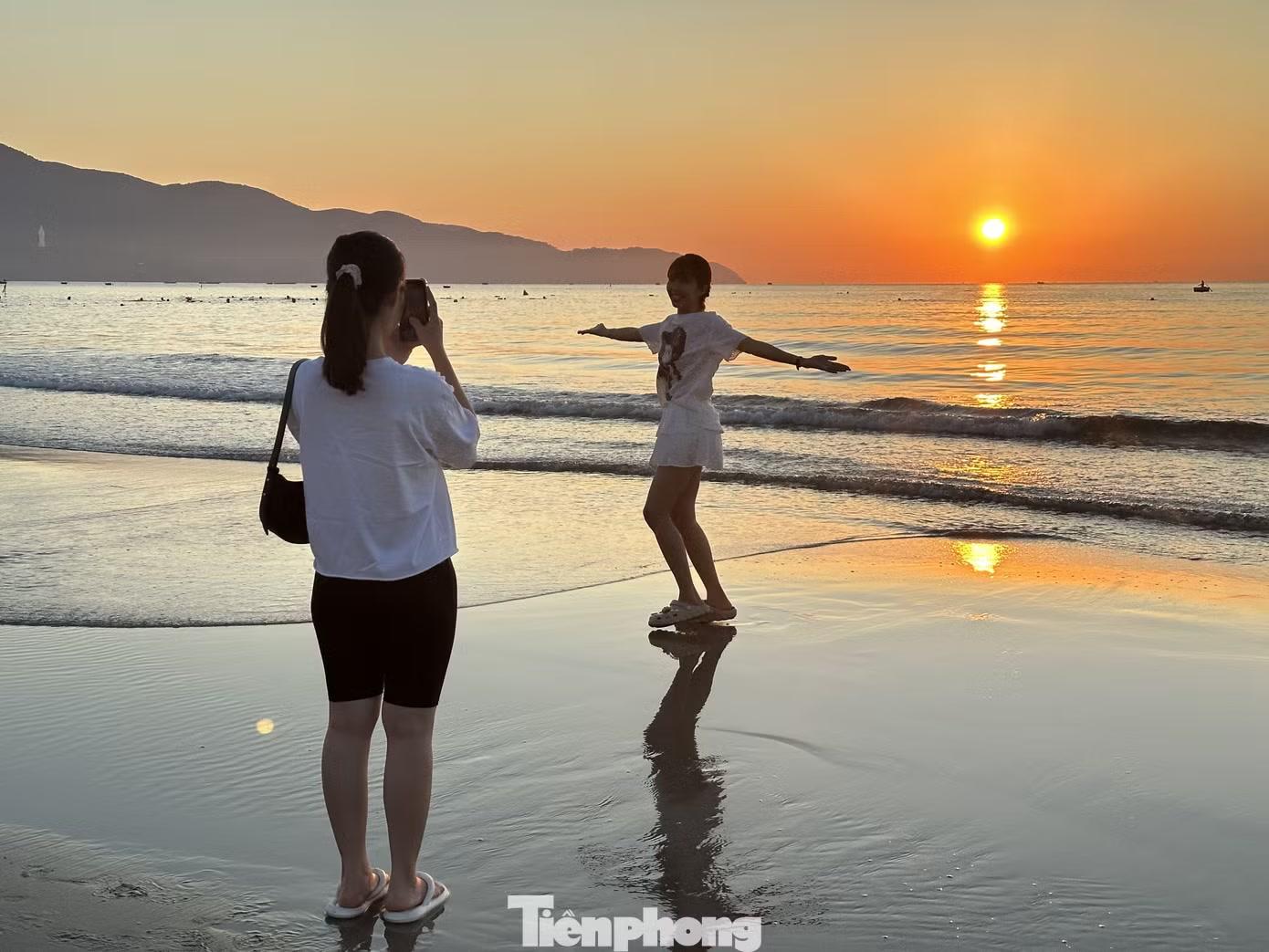  Nguyễn Thị Phương Thảo (27 tuổi) đến biển Mỹ Khê khi mặt trời vừa lên. “Mình chuyển đến Đà Nẵng được khoảng một năm nay. Vì ở gần biển nên khi mùa hè tới, mình thường dành thời gian chạy bộ và ngồi ngắm bình minh ở đây. Sáng nay mình dẫn bạn đến biển để chụp hình kỷ niệm”, Thảo kể. Ảnh: Khánh Đoan 