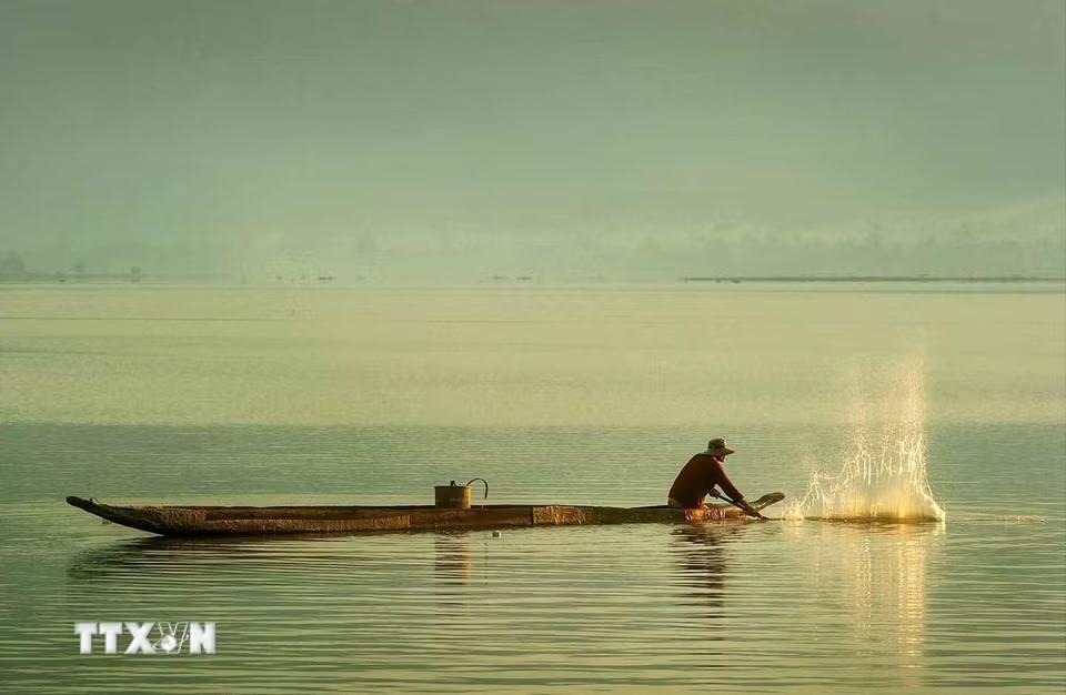 Người M'Nông đánh bắt cá trong lòng hồ Lắk bằng thuyền độc mộc. (Ảnh: Kha Phạm/TTXVN)