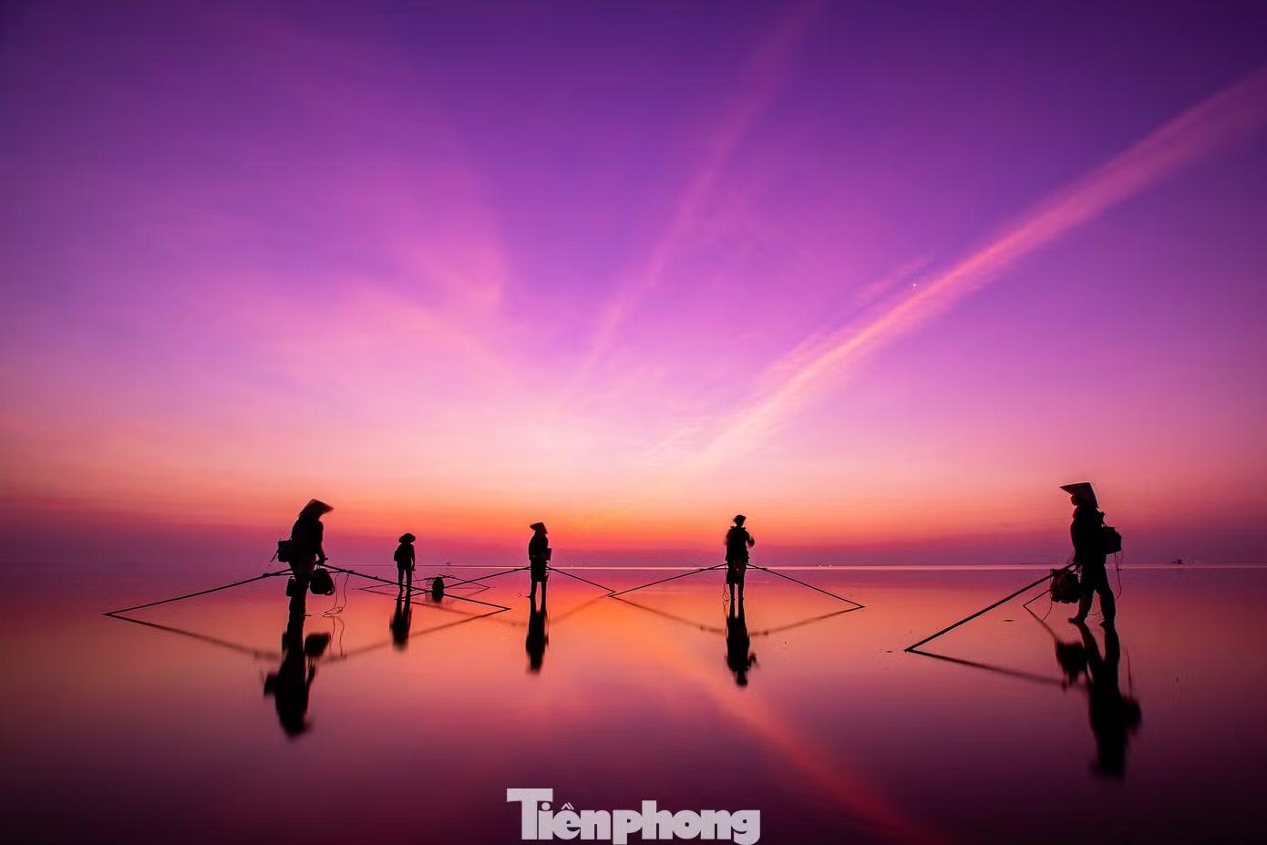 Mặt trời chưa ló rạng, ngư dân đã có mặt trên bãi triều để mưu sinh theo con nước. Hình ảnh kéo lưới, cào ngao, thu gom hải sản hiện lên nổi bật trên mặt nước phản chiếu, tạo nên những điểm nhấn sinh động giữa không gian biển trời mênh mang.