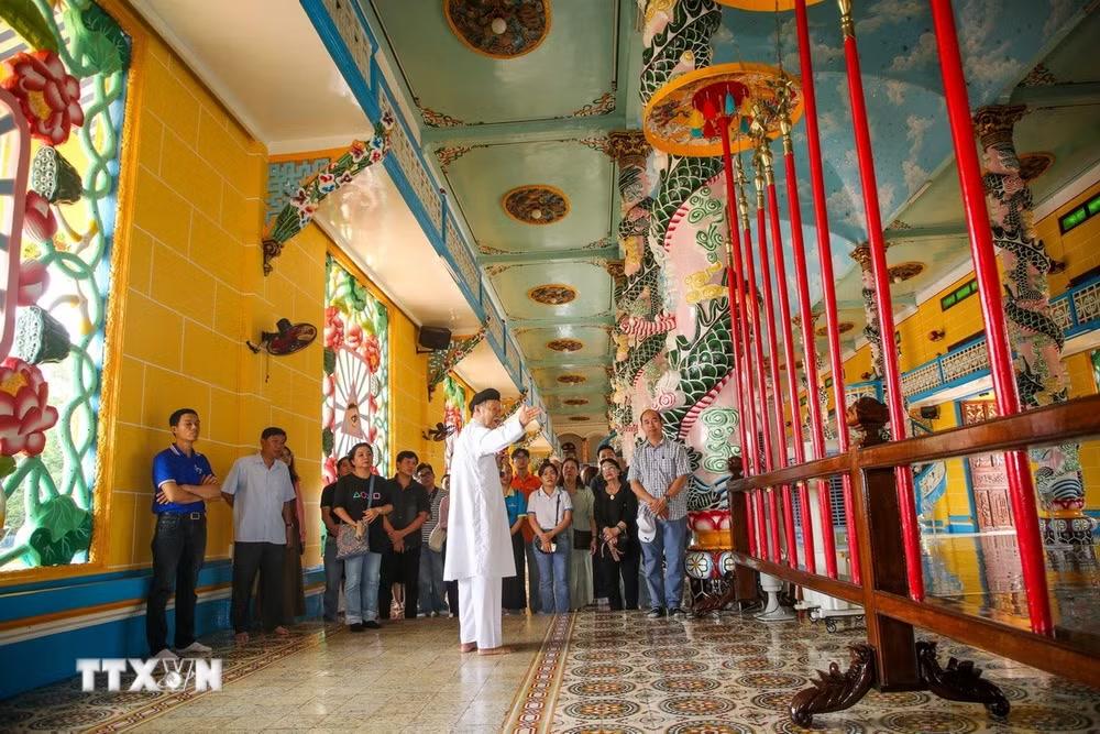 Du khách tham quan, tìm hiểu kiến trúc độc đáo bên trong chánh điện Tòa Thánh Cao Đài Tây Ninh. (Ảnh: Giang Phương/TTXVN)