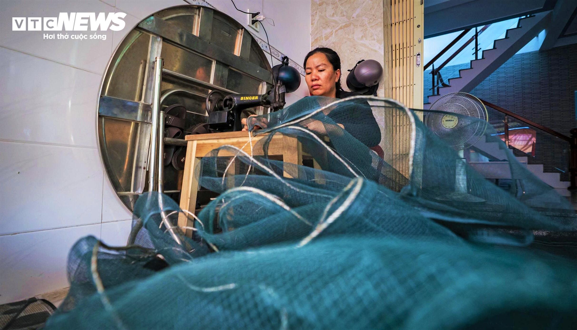 Tranh thủ thời gian rảnh, phụ nữ làng chài lại may vá lưới cho kịp chồng, con đi chuyến biển mới.