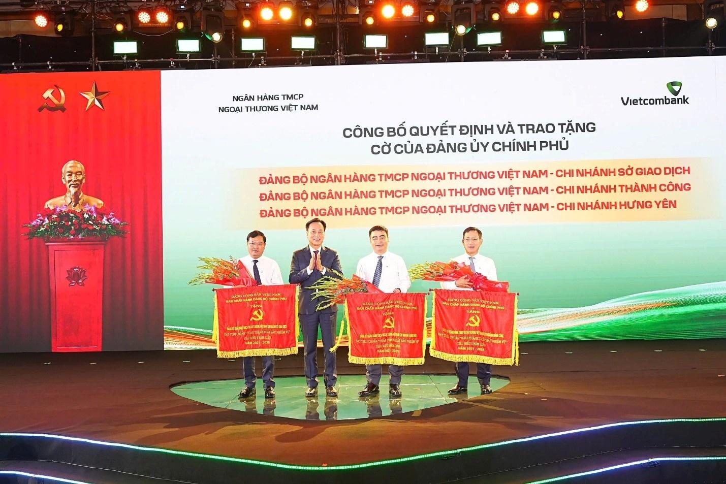  Đại diện Đảng ủy Chính phủ, đồng chí Lại Xuân Lâm, Phó Bí thư chuyên trách, trao cờ và tặng hoa cho đại diện 3 Đảng bộ trực thuộc Vietcombank được công nhận đạt tiêu chuẩn hoàn thành xuất sắc nhiệm vụ tiêu biểu giai đoạn 2021-2025. 