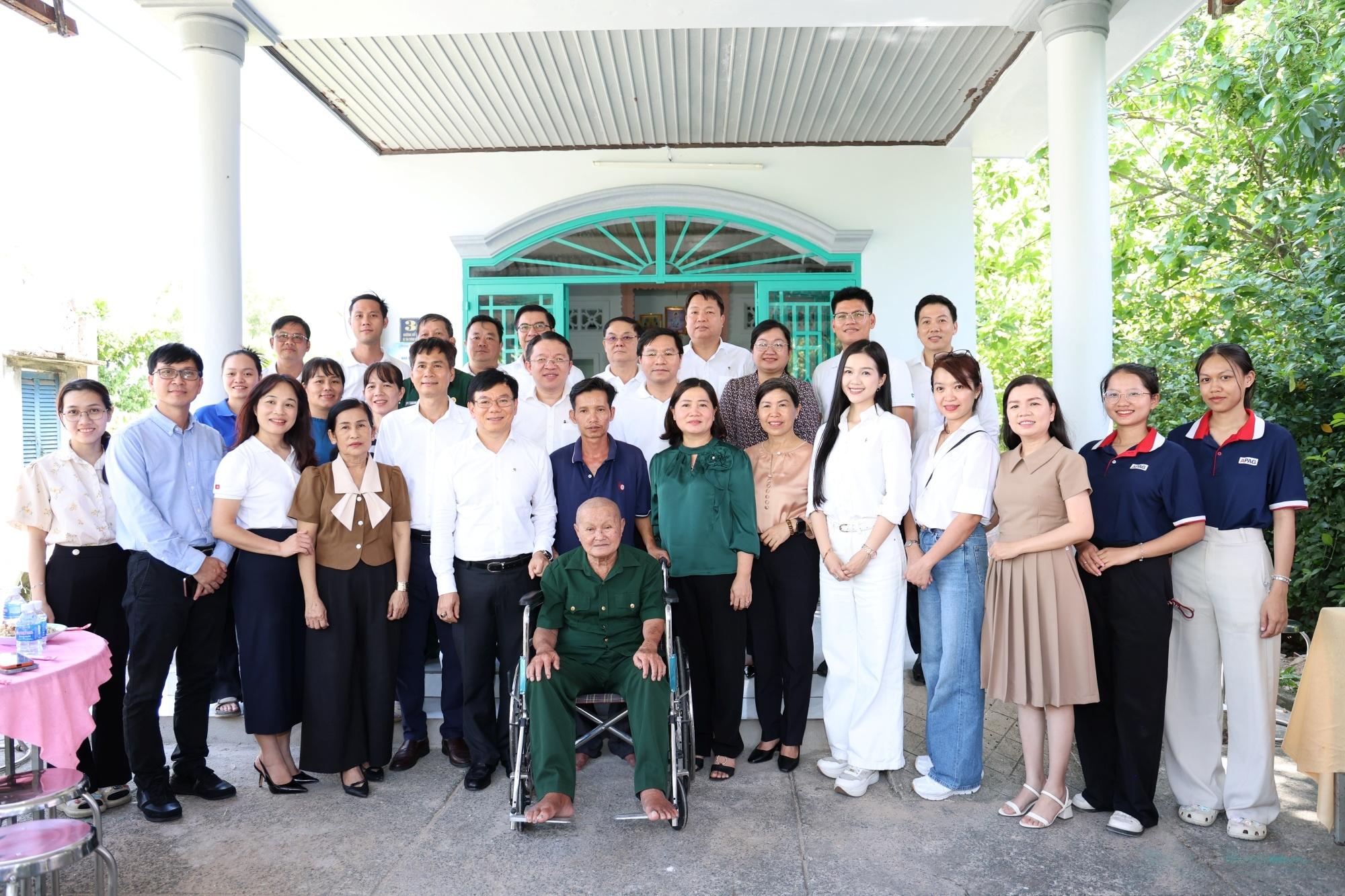 Đại diện Vietcombank, báo Tiền Phong, chính quyền địa phương, các gia đình cựu chiến binh và người dân chụp ảnh lưu niệm trước ngôi nhà mới của cựu chiến binh Châu Văn Đực (xã Củ Chi).