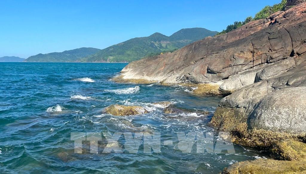 Những hòn đá xám sẫm nằm rải rác dưới chân núi Hải Vân, như những mảnh ghép thô ráp của thiên nhiên xen lẫn giữa vẻ đẹp dịu dàng của biển xanh Lăng Cô. Ảnh: Văn Dũng-TTXVN