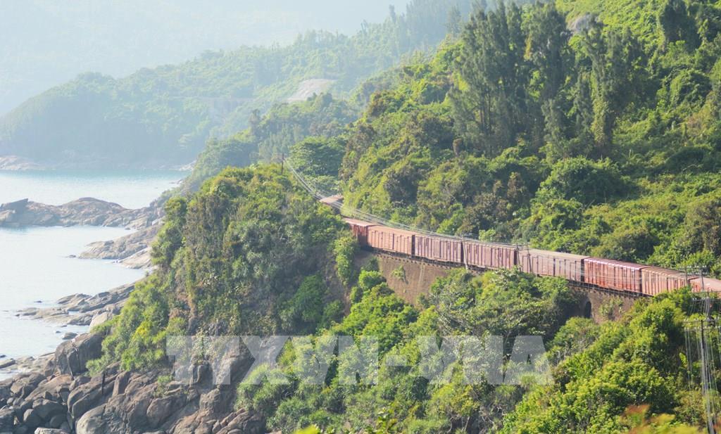 Khi những toa tàu uốn lượn sát mép vịnh, thân tàu nhỏ bé như một dải lụa mềm mại trôi giữa khung cảnh thiên nhiên rộng lớn. Ảnh: Văn Dũng-TTXVN