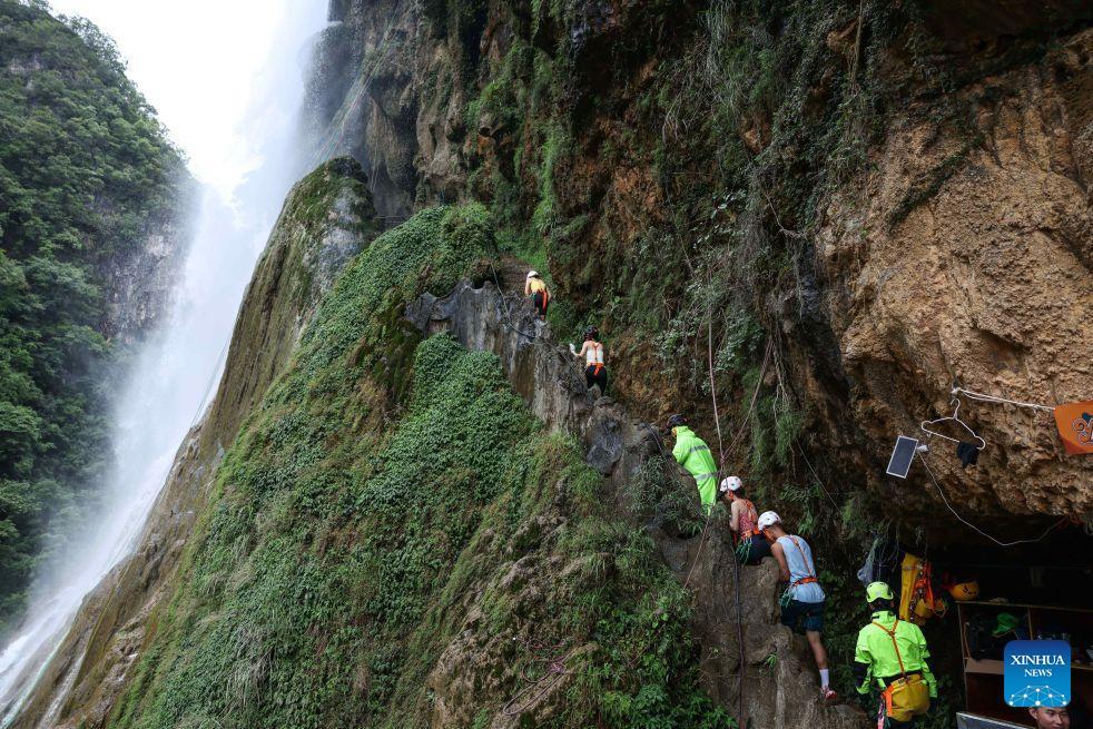  Du khách cùng nhân viên di chuyển đến khu vực trải nghiệm đu dây vượt thác. Những năm gần đây, huyện Hoàng Bình phát triển mô hình du lịch kết hợp thác nước sinh thái, đu dây vượt thác và thưởng thức cà phê giữa núi rừng, từng bước đổi mới các sản phẩm tham quan truyền thống. 