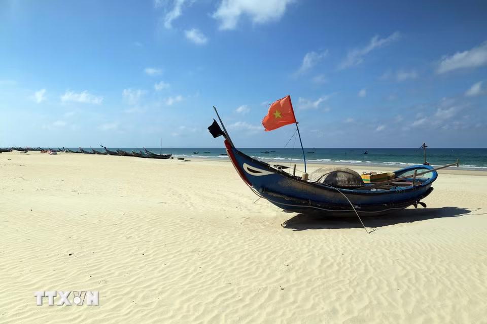 Những chiếc thuyền khai thác hải sản nhỏ của ngư dân nằm "phơi mình" trên bãi cát trắng mịn sau chuyến biển trở về. (Ảnh: Đỗ Trưởng/TTXVN)