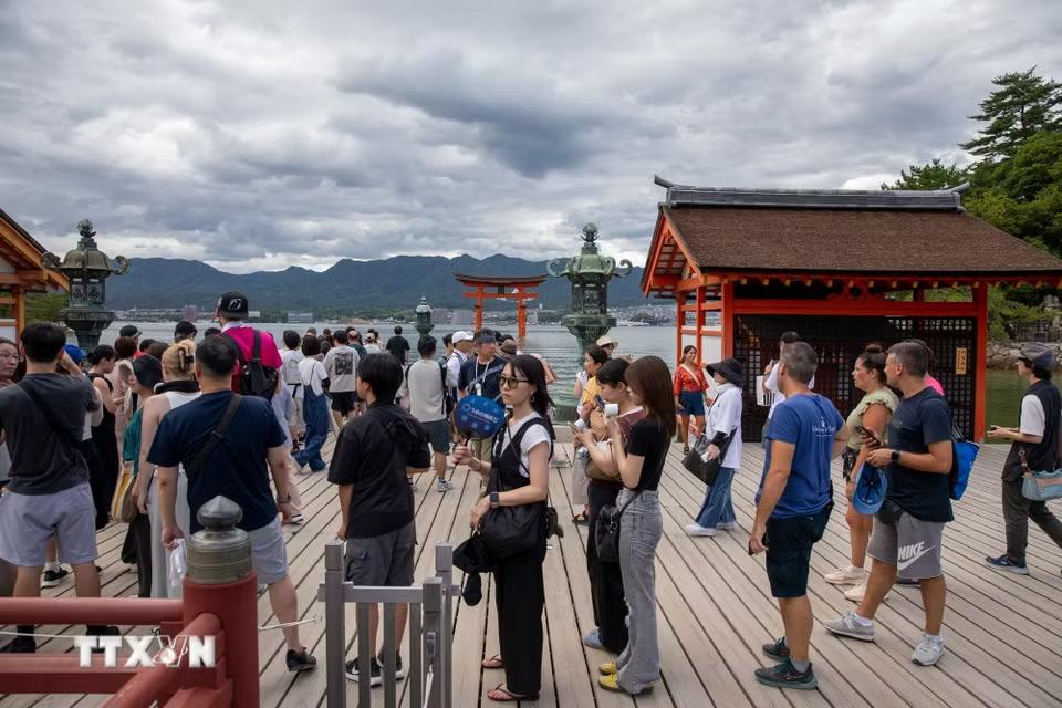 Du khách xếp hàng để chụp ảnh lưu niệm cùng cánh cổng Torii. (Ảnh: Xuân Giao/TTXVN)