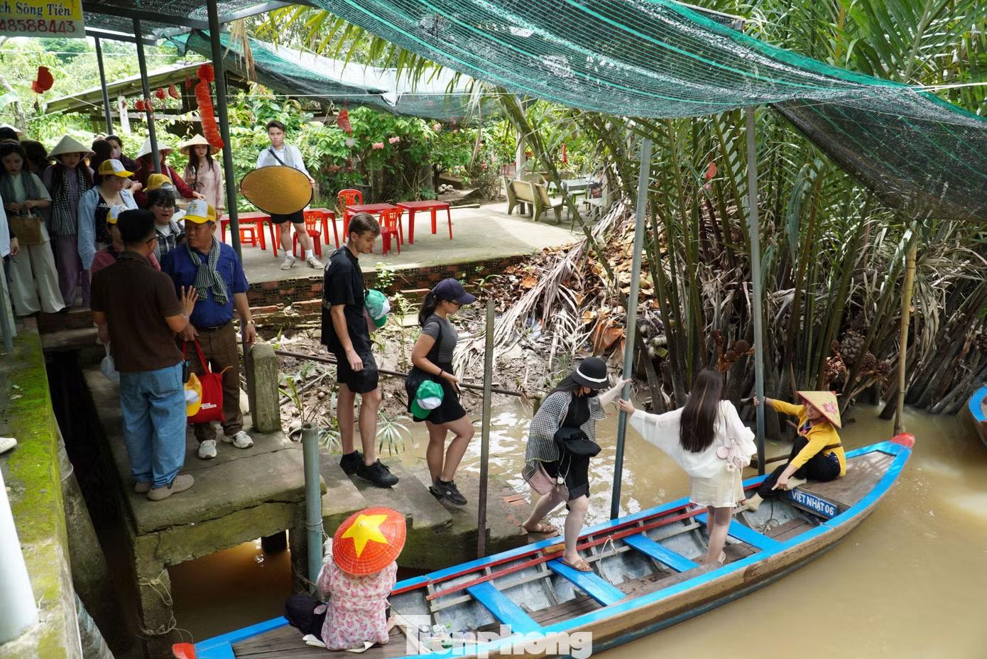  Giữa trưa nắng gắt của mùa hè, không khí tại bến đò cồn Thới Sơn nhộn nhịp khi lượng khách đổ về ngày càng đông để trải nghiệm xuồng ba lá. Ảnh: Hòa Hội 