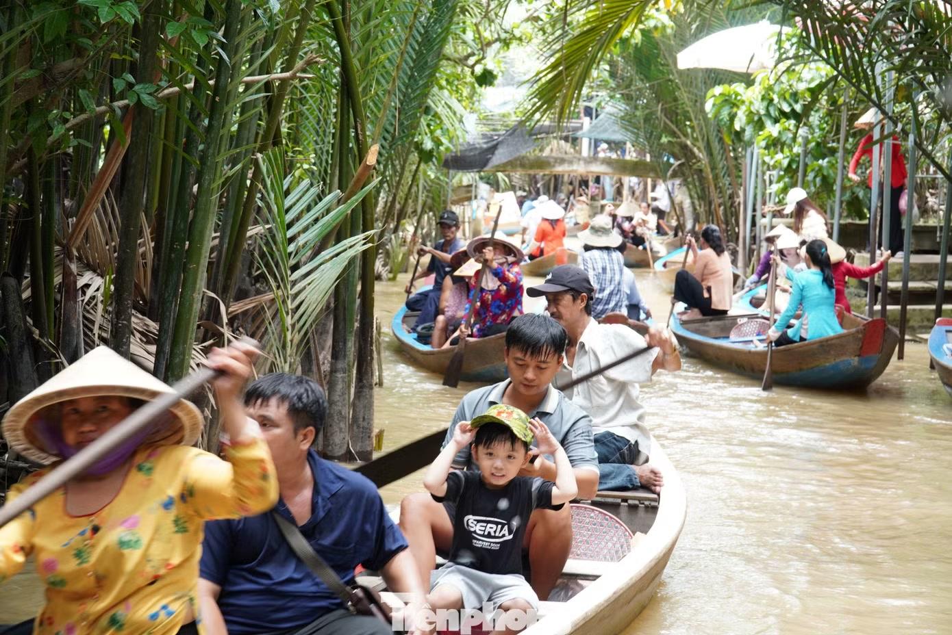 Con rạch Bà Ngoạn nhỏ xíu, uốn lượn dưới những rặng dừa nước xuồng ba lá chở du khách tấp nập qua lại.