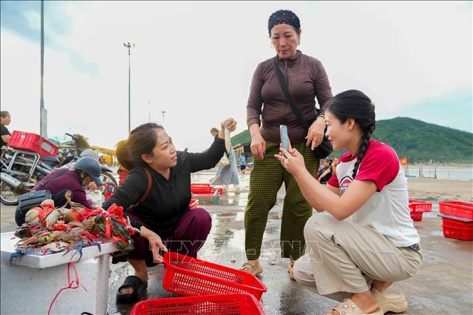Khách mua hải sản tại cảng cá Cửa Nhượng.
