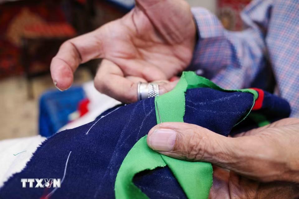 Ông Ahmed, nghệ nhân hơn 50 năm tuổi nghề, tập trung hoàn thiện một bức tranh khổ lớn. (Ảnh: Hoàng Nhật/TTXVN)
