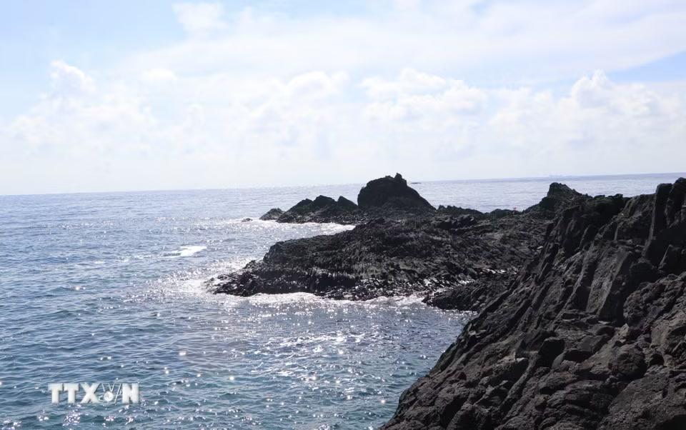 Những khối đá đen bazan, đá ong là vết tích nham thạch phun trào hàng triệu năm tại Hòn Nhàn. (Ảnh: Đinh Hương/TTXVN)