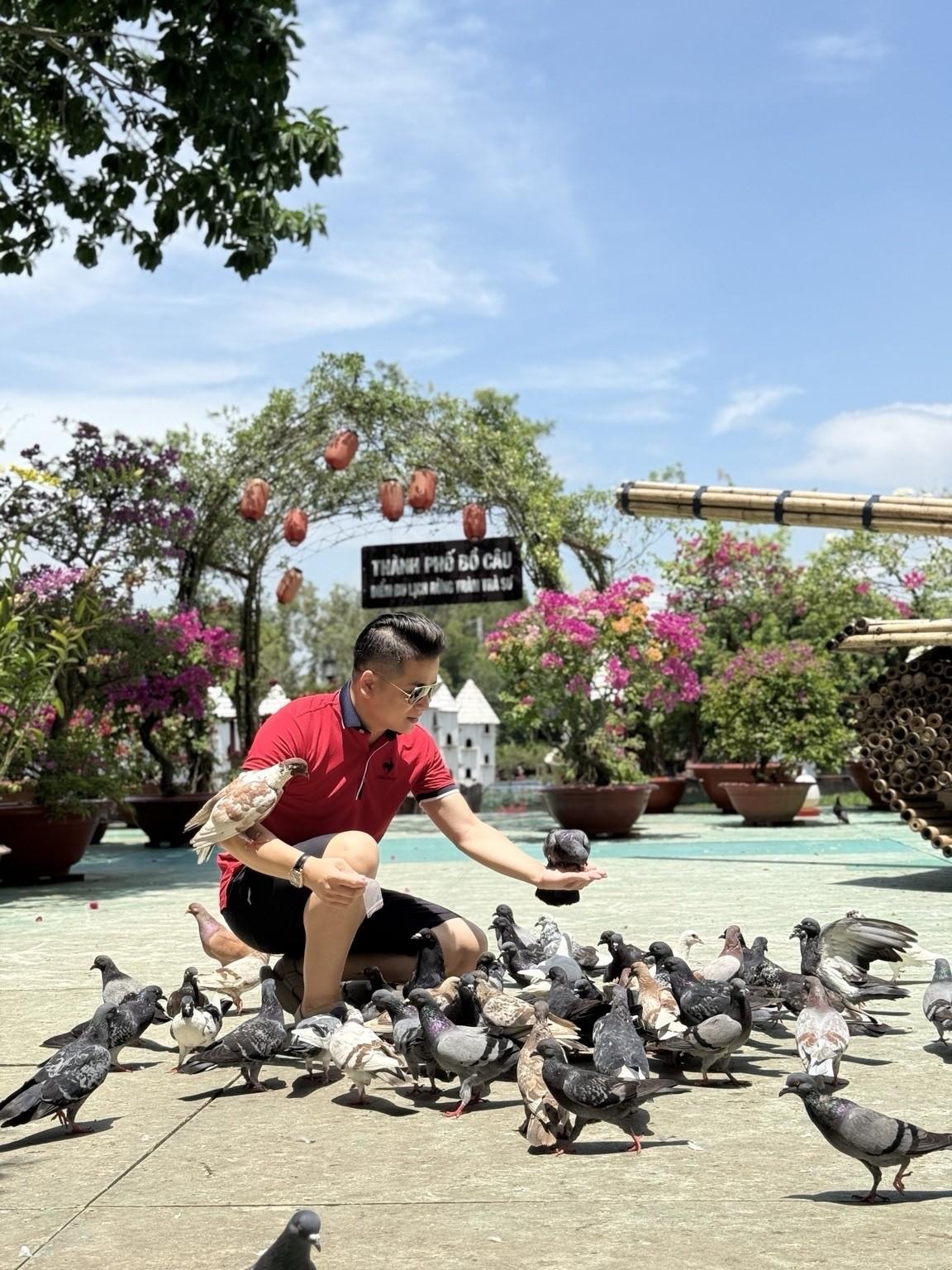 Du khách trải nghiệm gần gũi với đàn bồ câu tại " Thành phố Bồ Câu", một trong những điểm dừng chân trong hành trình tham quan Trà Sư. Ảnh: Bình Minh
