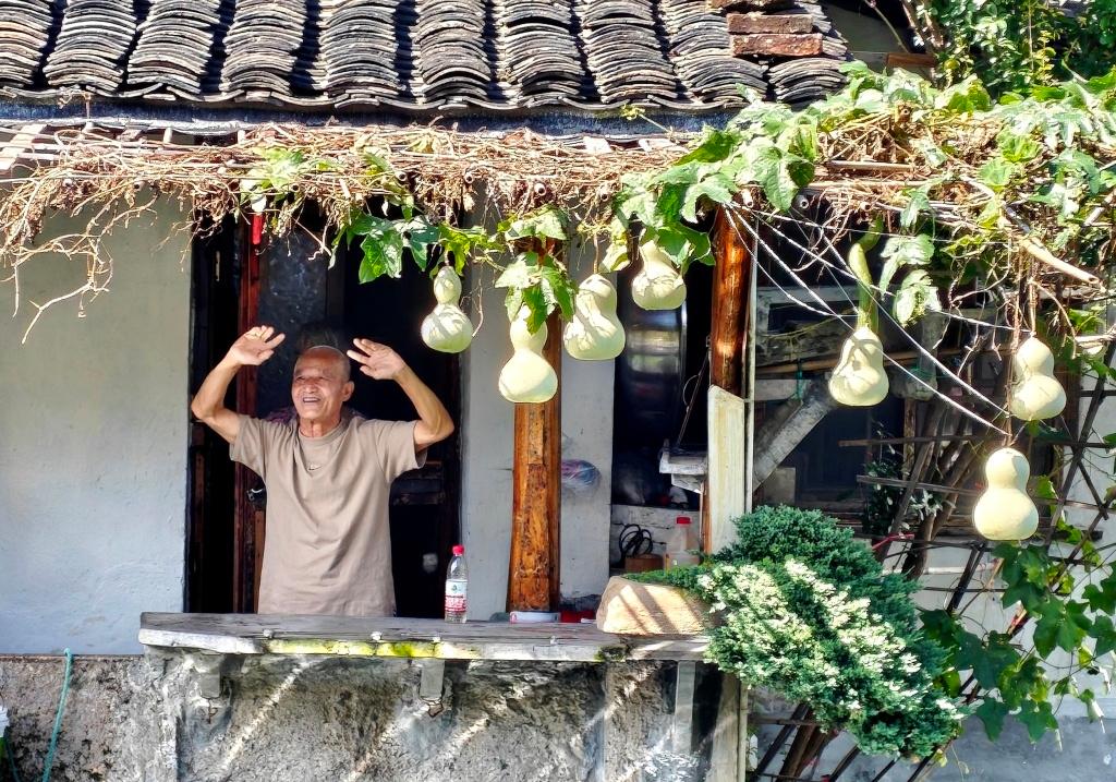  Ông Chen đang vẫy tay chào du khách từ ban công nhà. Ảnh: VCG. 