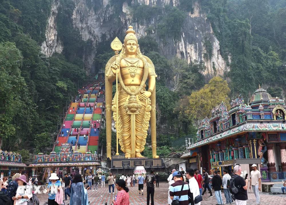 Tượng thần Murugan trước lối lên Động Batu và phía sau là cầu thang nhiều màu dẫn du khách lên khu đền và hang động bên trong núi đá vôi. (Ảnh: Thanh Bình/TTXVN)