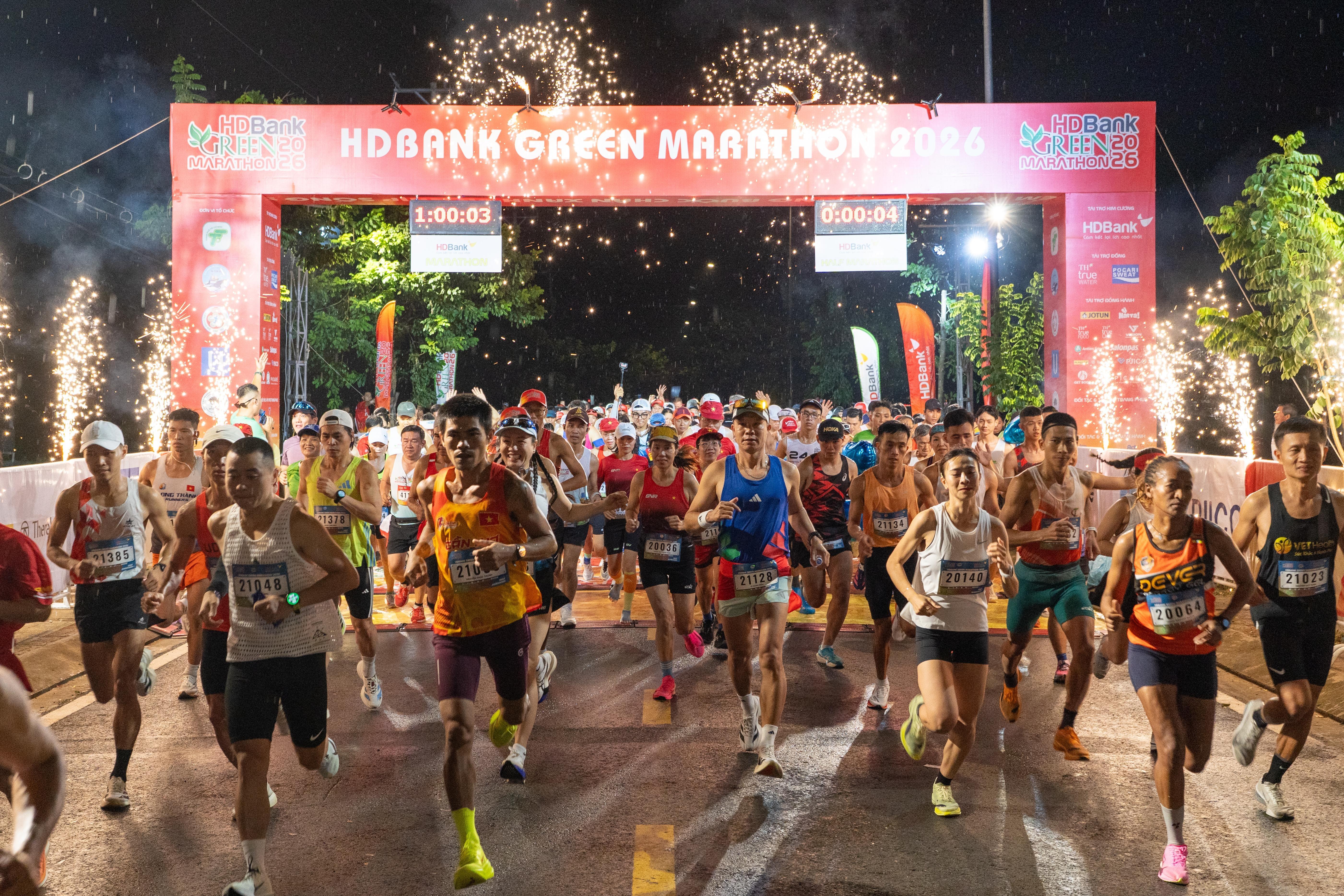  Khi phần lớn Cần Giờ còn chìm trong màn đêm, khu vực xuất phát HDBank Green Marathon 2026 đã sáng đèn và phủ kín runner. Thời điểm cự ly đầu tiên chuẩn bị khởi tranh, mưa bắt đầu nặng hạt khiến mặt đường trơn trượt, phần nào ảnh hưởng đến hiệu suất chạy của vận động viên (VĐV). Dẫu thử thách tăng lên, không khí trước giờ xuất phát vẫn đầy quyết tâm. Các cự ly 42 km, 21 km, 10 km và 5 km lần lượt bước vào đường chạy theo từng khung giờ. Sau hiệu lệnh, dòng runner rời vạch xuất phát giữa màn mưa, những bước chân nối tiếp nhau mở đầu ngày tranh tài chính của mùa giải thứ 5. 