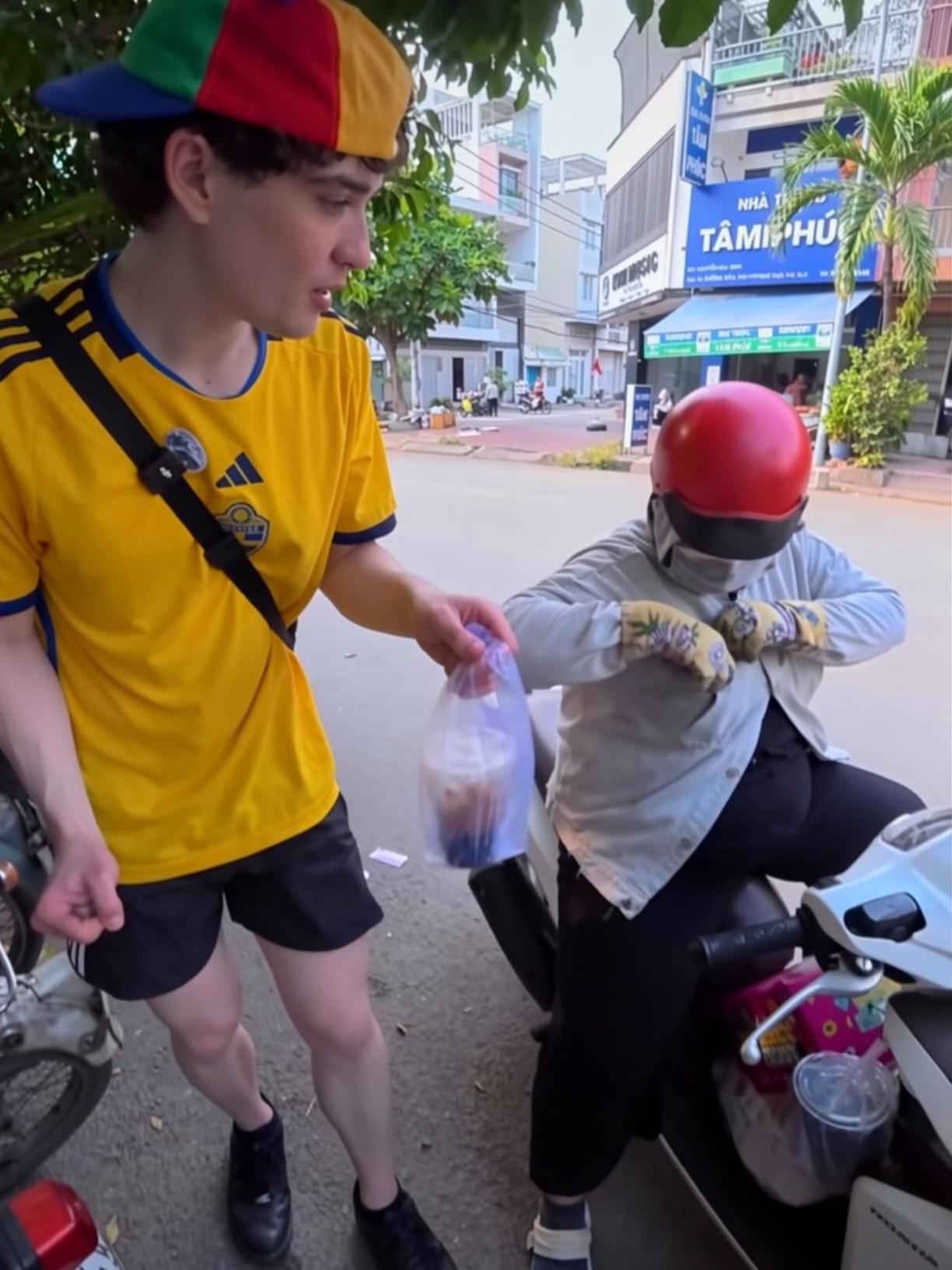 Người phụ nữ dùng xe máy của mình chở nam du khách đến quán cà phê. Ảnh: Robert Berg.