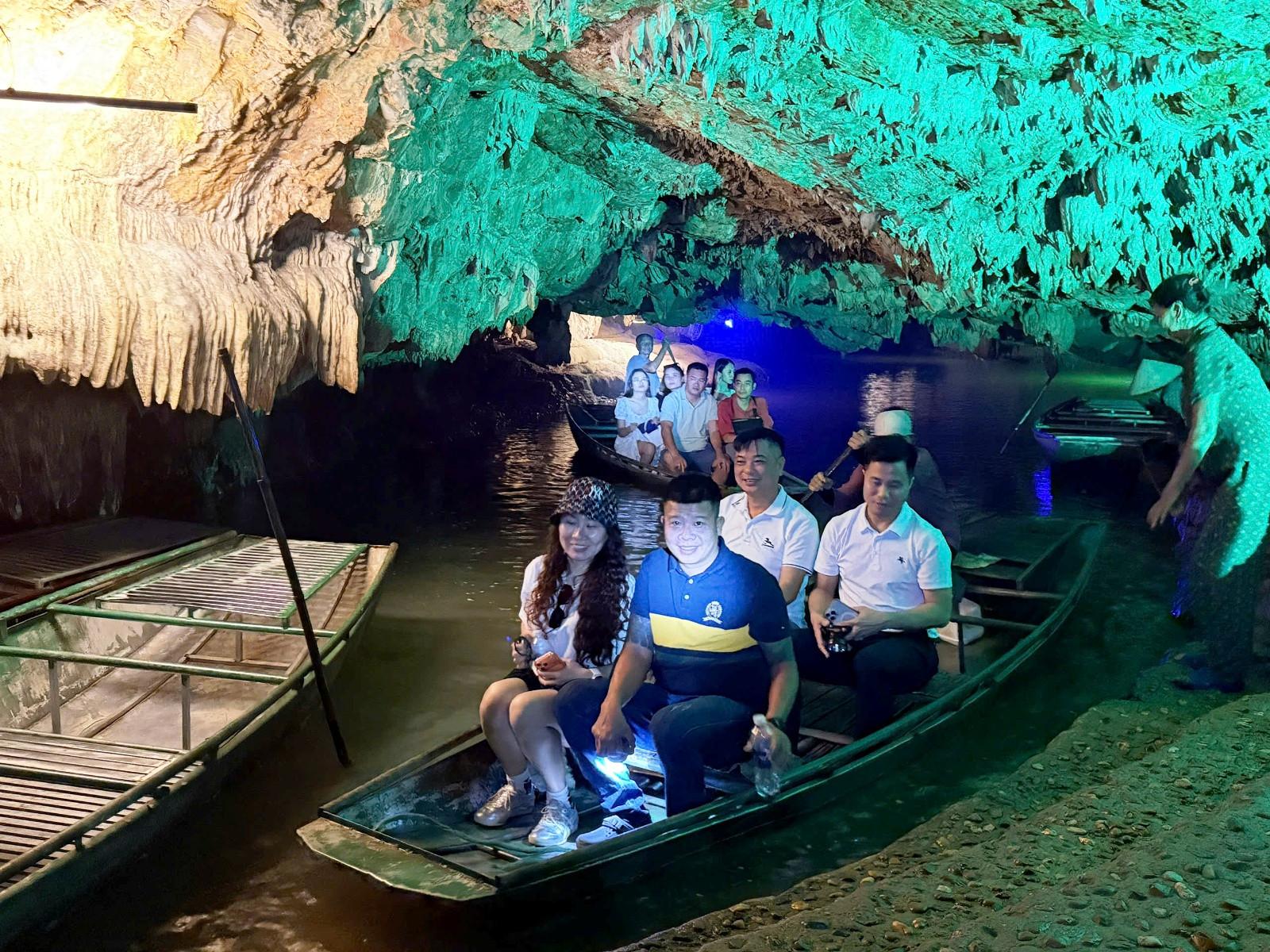 Du khách ngồi thuyền trên sông ngầm với hàng vạn khối nhũ đá lấp lánh phản chiếu xuống dòng nước cảm giác như đang trôi giữa dải ngân hà với vô số vì sao tỏa sáng. Ảnh: Thiên Hà