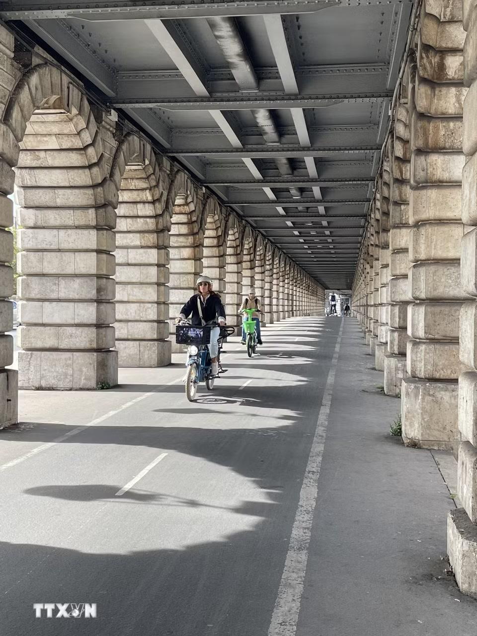 Cầu Bercy: Làn đường dành cho xe đạp chạy dưới phần cầu mở rộng của cầu Bercy, tạo nên hành lang đặc trưng với những nhịp đá lặp lại. Cầu được xây lại bằng đá năm 1864 và mở rộng đầu thế kỷ XX để đón cầu cạn của tuyến metro số 6. (Ảnh: Trần Đức Hùng/TTXVN)