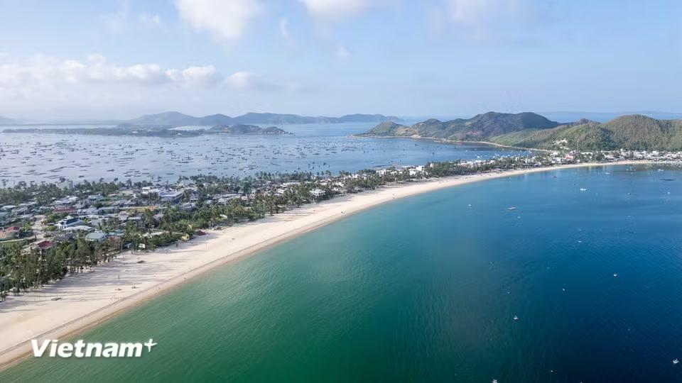 Bãi biển Vịnh Hòa (thuộc phường Sông Cầu, tỉnh Đắk Lắk) nhìn từ trên cao mang vẻ đẹp hoang sơ, thơ mộng với đường bờ biển uốn cong mềm mại, hòa quyện giữa làn nước biển trong xanh và bãi cát trắng mịn màng. (Ảnh: Thanh Phong/Vietnam+)