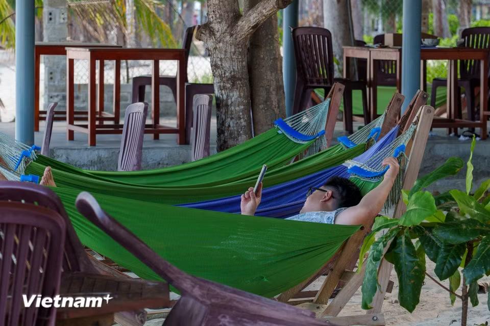 Du khách có thể thư giãn, ngả lưng trên những chiếc võng đung đưa dưới bóng râm và tận hưởng làn gió biển mát rượi đặc trưng của vùng biển Vịnh Hòa. (Ảnh: Thanh Phong/Vietnam+)