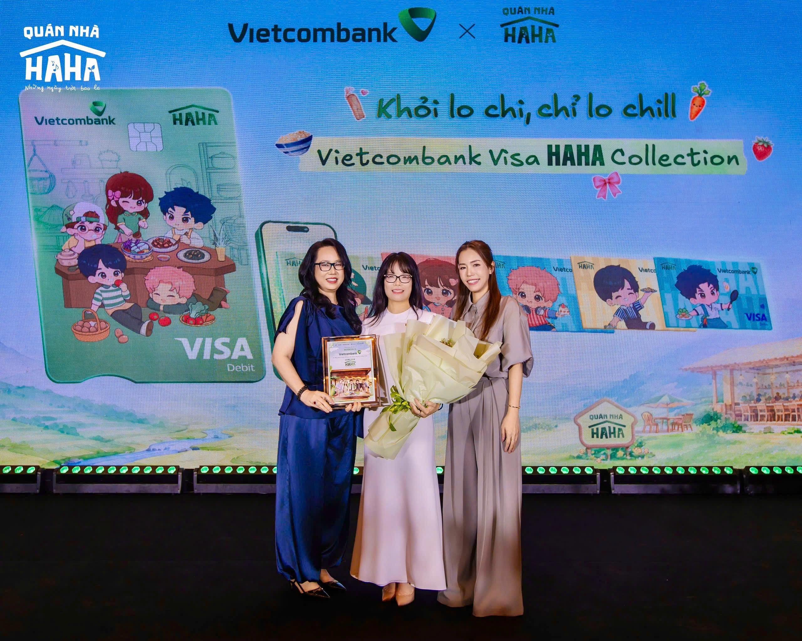  Bà Đoàn Hồng Nhung - thành viên BĐH, Giám đốc Khối Bán lẻ Vietcombank (giữa) - đại diện ngân hàng nhận hoa và biểu trưng từ đơn vị sản xuất tại họp báo ra mắt Quán nhà Haha. 
