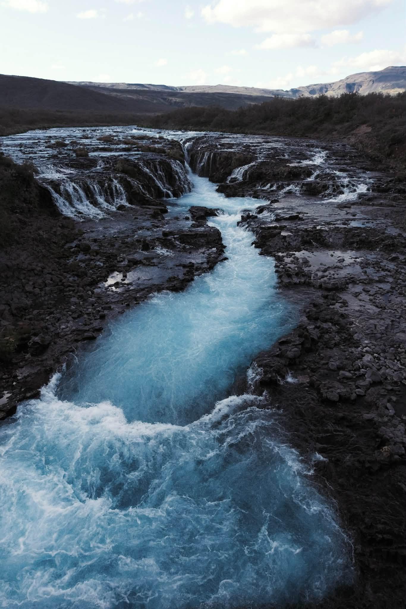 Bruarfoss - thác nước nổi tiếng ở miền nam Iceland, nổi bật với dòng nước màu xanh ngọc lam rực rỡ. Dòng nước chia thành nhiều nhánh nhỏ uốn lượn, đổ mạnh qua một khe nứt sâu hình móng ngựa, cắt ngang qua lớp đá bazan núi lửa màu đen