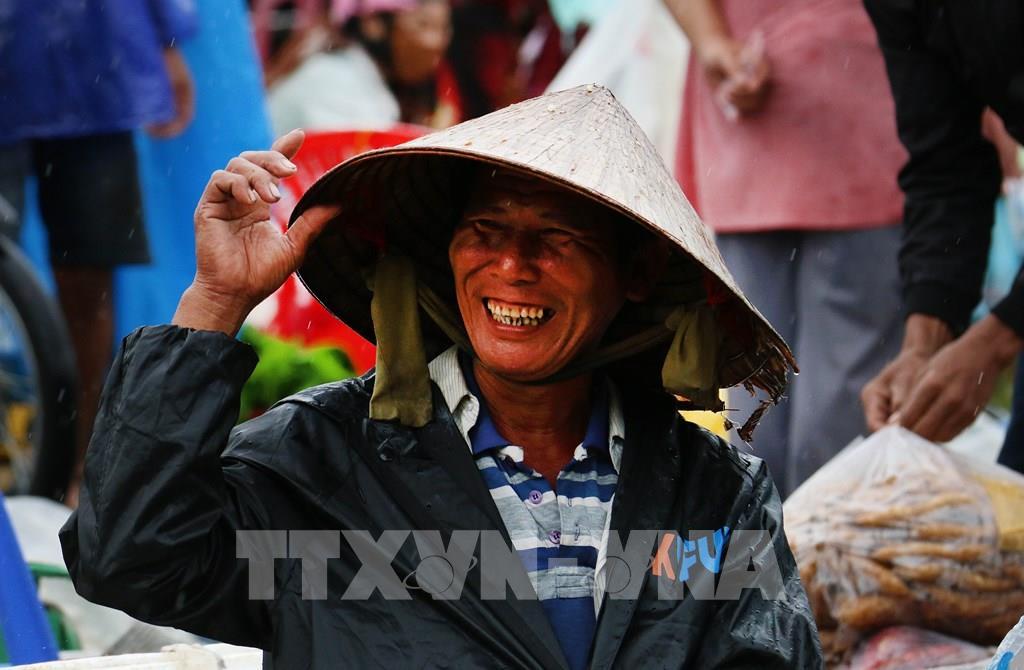 Nhiều hôm trời mưa, những người bán hàng vẫn tươi cười, kiên nhẫn ngồi bên những mẹt hàng giản dị, chờ khách ghé mua. Ảnh: Duy Khương – TTXVN