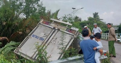 Xe tải tông lan can cầu rơi xuống kênh, tài xế mắc kẹt trong cabin