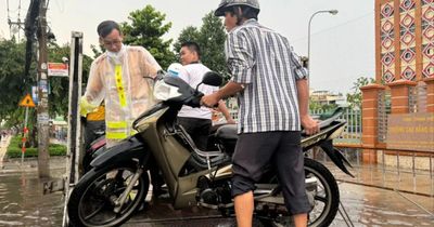 CSGT An Sương hỗ trợ người dân qua đoạn đường ngập sâu