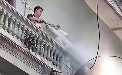 Người đàn ông liên tục xịt nước vào thợ đang tháo dỡ công trình