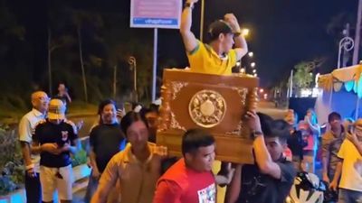 Nhóm người mặc áo trại hòm khiêng quan tài có người sống, nhảy múa trên đường