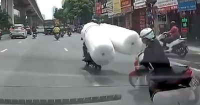 Thót tim xe máy chở hàng cồng kềnh khiến người phụ nữ ngã vào gầm ô tô