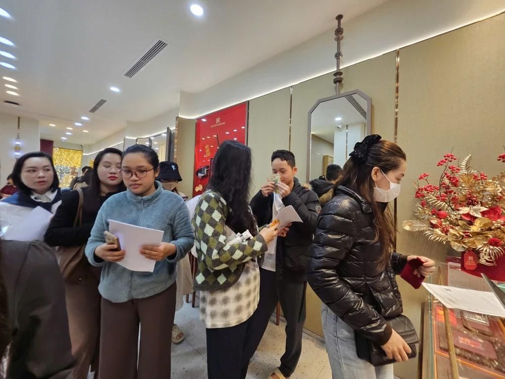 Người dân xếp hàng dưới mưa mua vàng trước ngày Thần tài