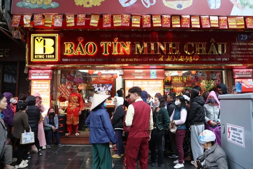 Người dân xếp hàng dưới mưa mua vàng trước ngày Thần tài