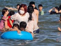 Du khách đeo khẩu trang tắm biển ở Sầm Sơn