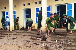 Công an dầm mình trong bùn lầy giúp người dân khắc phục hậu quả lũ lụt