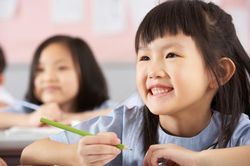 Học sinh Trung Quốc rèn tư thế viết bằng cách đặt cốc trên đầu
