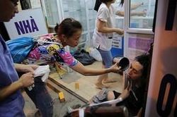 Hình ảnh người phụ nữ vẻ mặt lo lắng, dội nước sơ cứu cho chiến sĩ cứu hỏa hồi tỉnh gây xúc động mạnh