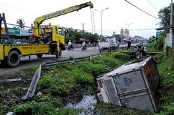 Xe tải tông sập dãy ta-luy rồi lật xuống kênh