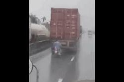 Điều khiển xe máy chạy bám đuôi xe công-ten-nơ để... trú mưa