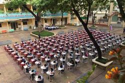 Học sinh tiểu học ngồi thẳng tắp thi vẽ giữa sân trường