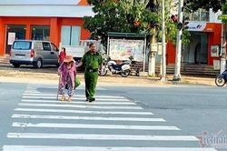 Đại úy công an dắt cụ bà qua đường