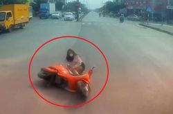 Cô gái đi xe máy vượt đèn vàng ngã trước đầu ôtô