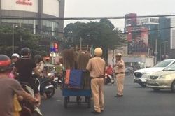 Xúc động hình ảnh CSGT giúp người mù đẩy xe bán chổi qua đường