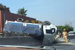 Ôtô tải lật ngửa trên dải phân cách sau khi vượt xe đầu kéo